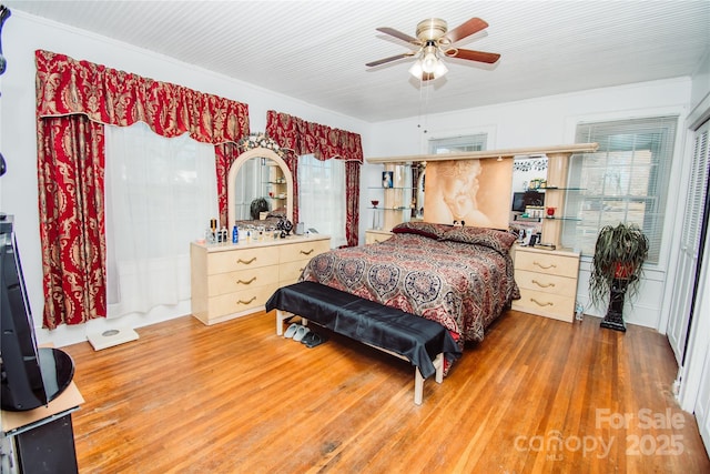 bedroom with multiple windows, hardwood / wood-style floors, and ceiling fan