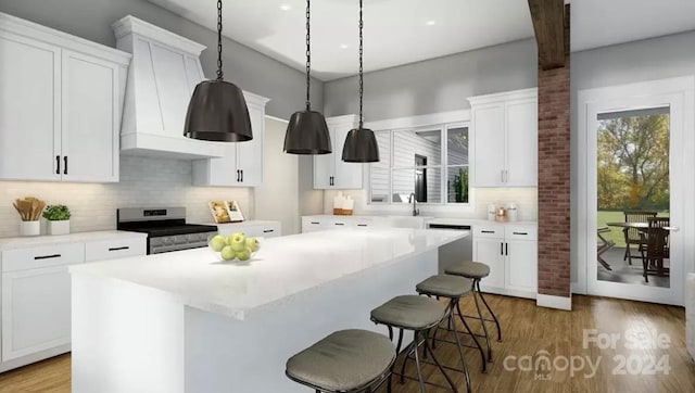 kitchen with custom exhaust hood, stainless steel appliances, wood-type flooring, a center island, and white cabinetry