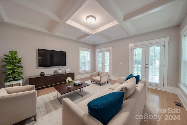 living room with coffered ceiling, beam ceiling, light hardwood / wood-style floors, and french doors