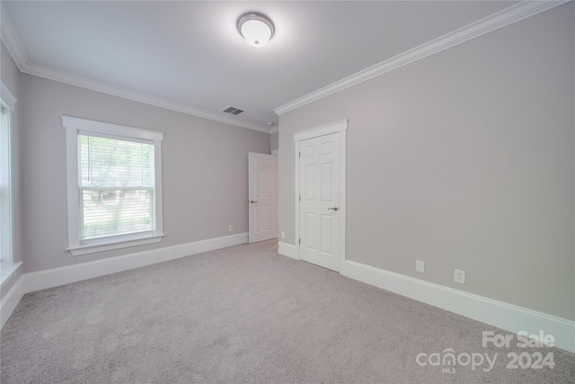 unfurnished room featuring light colored carpet and ornamental molding