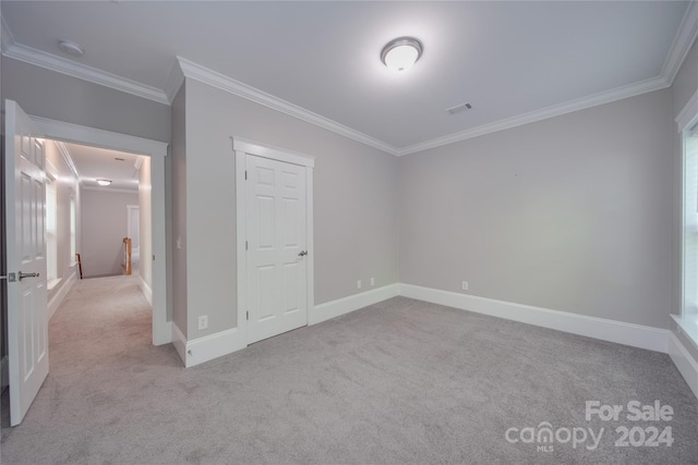 unfurnished bedroom featuring ornamental molding and light carpet