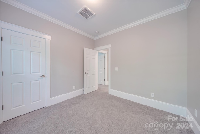 unfurnished bedroom with crown molding and light carpet