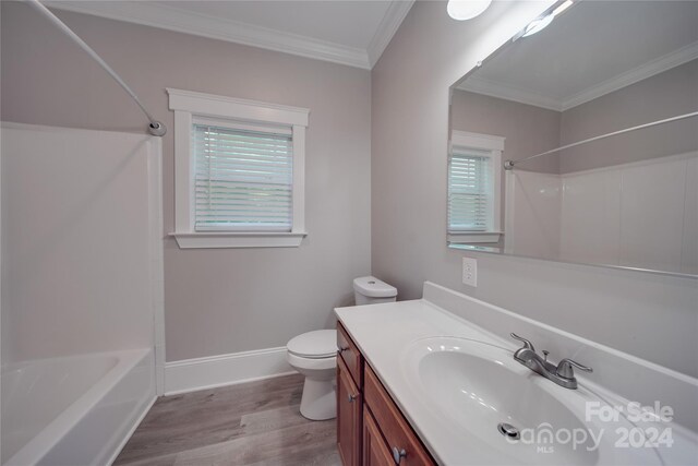 full bathroom with hardwood / wood-style floors, shower / bathing tub combination, ornamental molding, vanity, and toilet