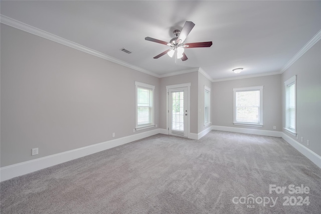 spare room with ceiling fan, a healthy amount of sunlight, ornamental molding, and light carpet