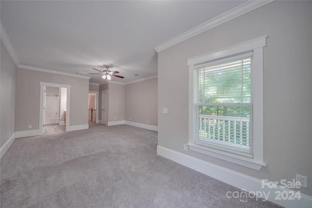 empty room featuring crown molding, light colored carpet, and ceiling fan