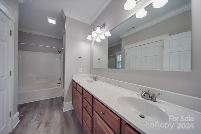 bathroom featuring hardwood / wood-style flooring, ornamental molding, bathing tub / shower combination, and vanity