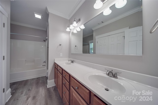 bathroom featuring vanity, hardwood / wood-style flooring, ornamental molding, and shower / bathtub combination