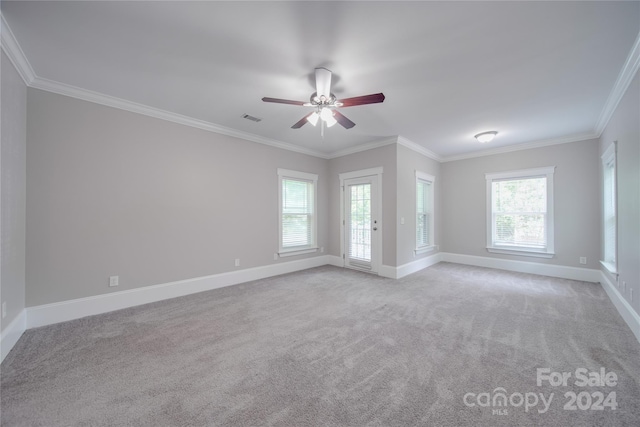 empty room featuring crown molding, light colored carpet, and ceiling fan