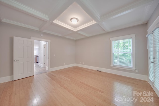 empty room featuring beamed ceiling, wood-type flooring, and coffered ceiling