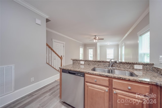 kitchen featuring sink, stainless steel dishwasher, light stone counters, and light wood-type flooring