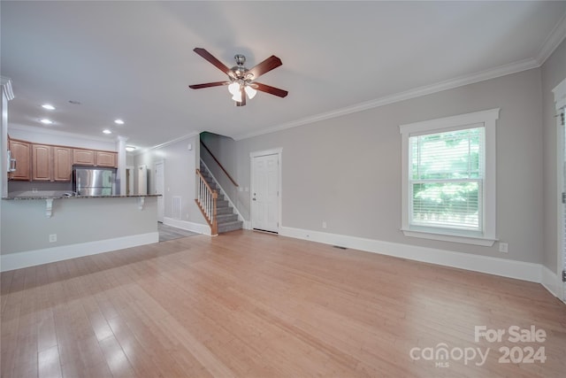 unfurnished living room featuring crown molding, light hardwood / wood-style floors, and ceiling fan