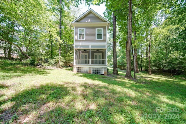 rear view of property with a yard and ceiling fan