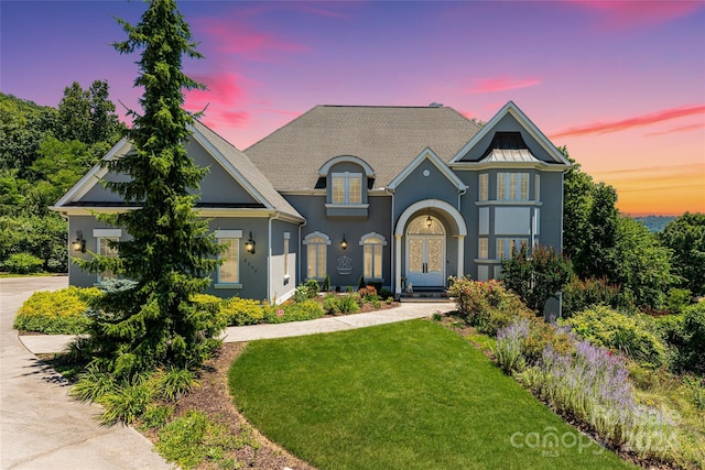 view of front facade featuring french doors and a yard