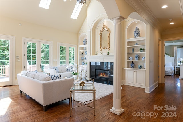 living room with built in shelves, plenty of natural light, a fireplace, and dark wood-type flooring