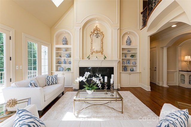 living room with built in shelves, dark wood-type flooring, and a premium fireplace