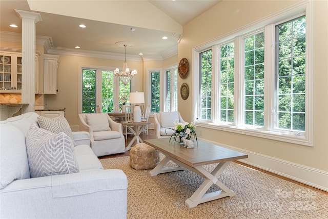 living room featuring light wood-type flooring, lofted ceiling, a wealth of natural light, and an inviting chandelier