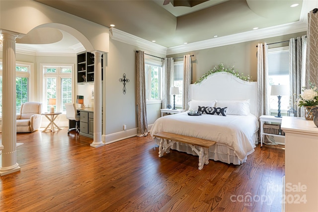 bedroom with ornate columns, ceiling fan, wood-type flooring, and ornamental molding