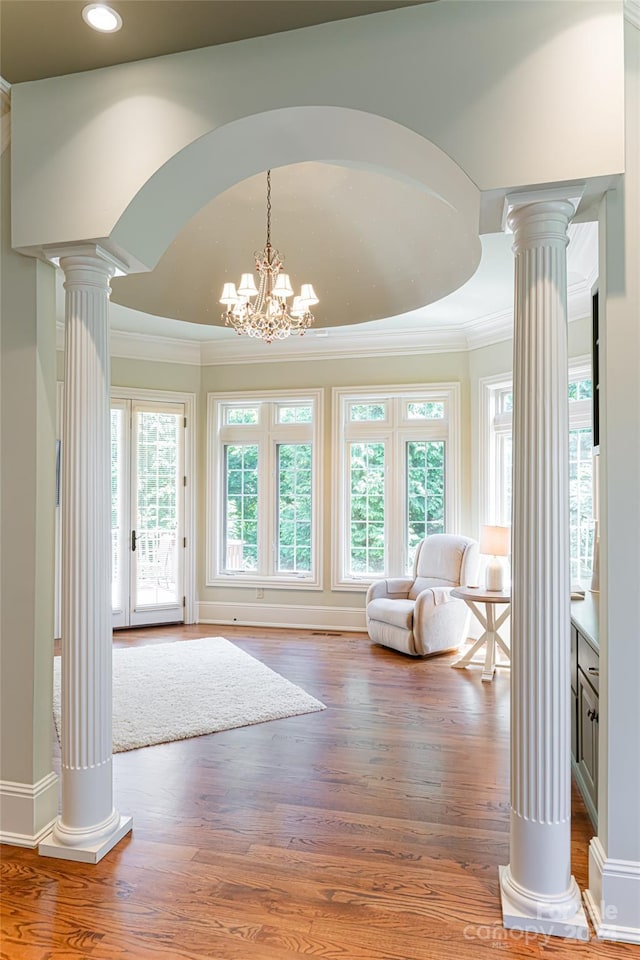 interior space with crown molding, hardwood / wood-style flooring, and an inviting chandelier