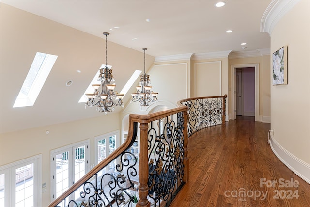 hall featuring vaulted ceiling with skylight, dark wood-type flooring, and ornamental molding