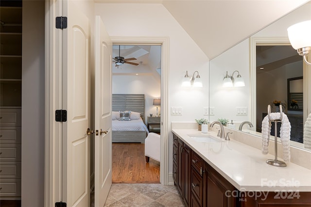 bathroom featuring vanity, vaulted ceiling, and ceiling fan