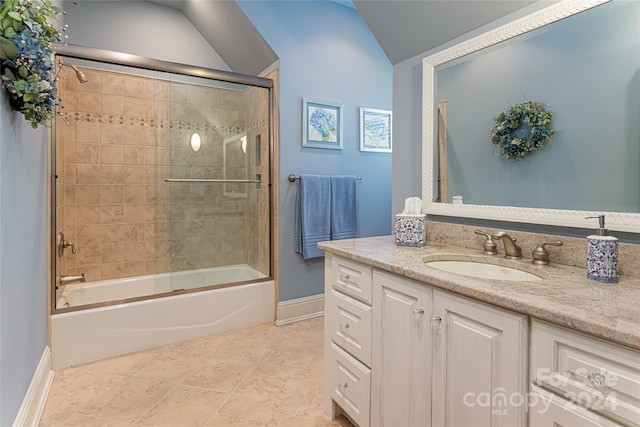 bathroom featuring tile patterned flooring, vanity, combined bath / shower with glass door, and vaulted ceiling