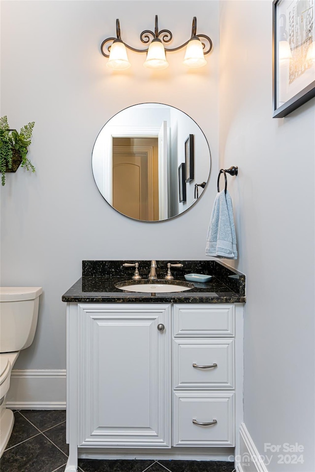 bathroom featuring tile patterned flooring, vanity, and toilet