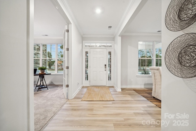 foyer entrance with light hardwood / wood-style flooring and ornamental molding