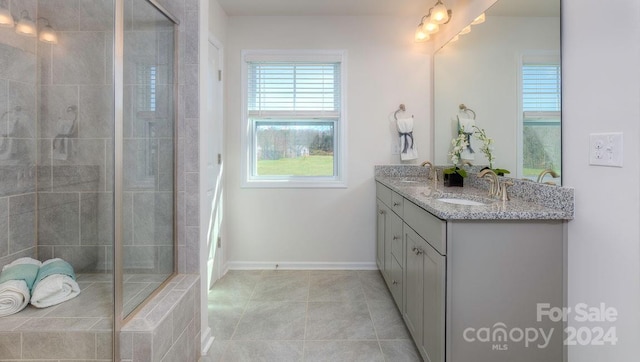 bathroom featuring tile patterned floors, vanity, and tiled shower