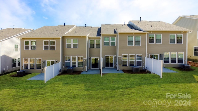 rear view of property with a yard, cooling unit, and a patio