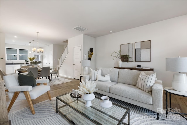 living room with sink, hardwood / wood-style flooring, and a chandelier