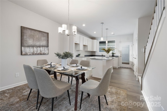 dining space with dark hardwood / wood-style flooring and a chandelier