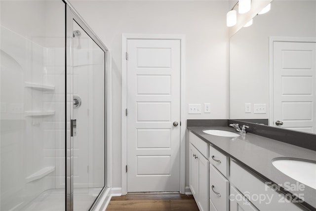 bathroom with hardwood / wood-style flooring, vanity, and an enclosed shower