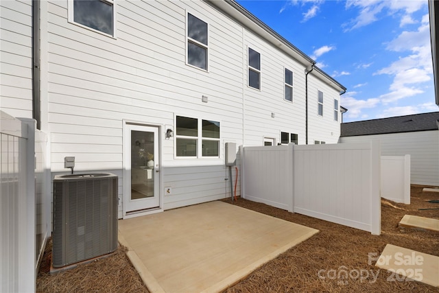 rear view of house featuring central AC unit and a patio