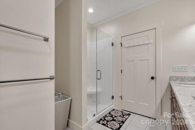 bathroom with a shower with shower door, tile patterned floors, and vanity