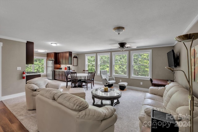 living room featuring ceiling fan, light wood-type flooring, and ornamental molding