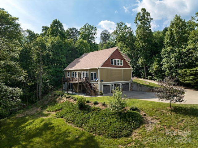 rear view of house featuring a wooden deck, a yard, and a garage