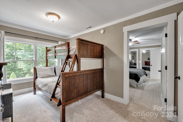 carpeted bedroom featuring a textured ceiling and crown molding