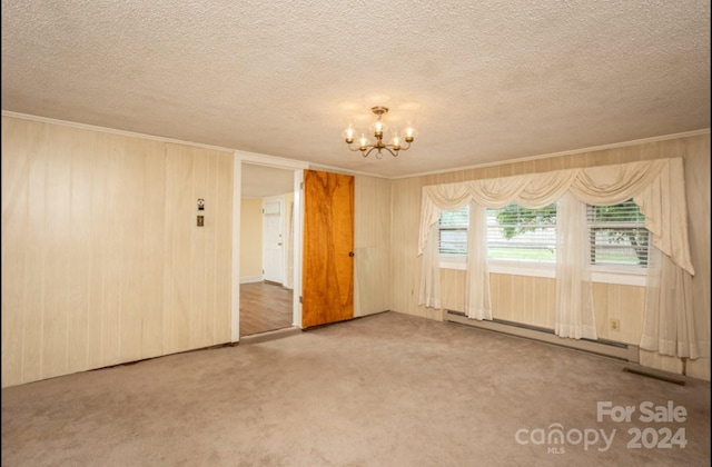 carpeted empty room featuring baseboard heating, an inviting chandelier, and a textured ceiling