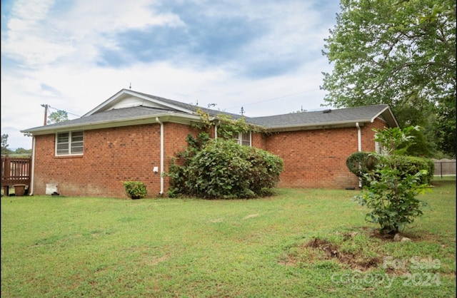 view of side of home with a yard