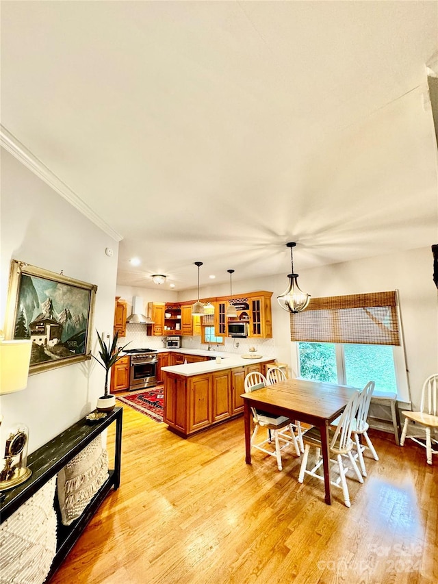 dining room featuring crown molding, light hardwood / wood-style floors, and sink