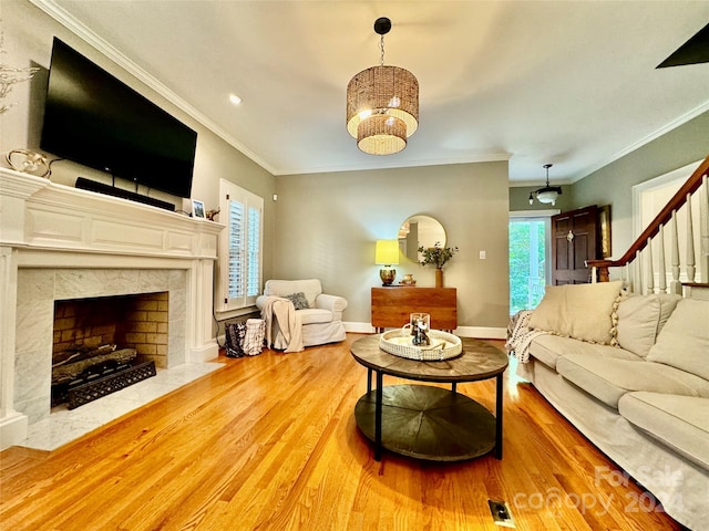 living room with hardwood / wood-style floors, a high end fireplace, and crown molding