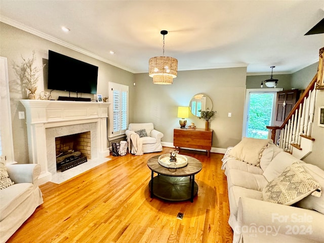 living room with a premium fireplace, crown molding, and hardwood / wood-style floors