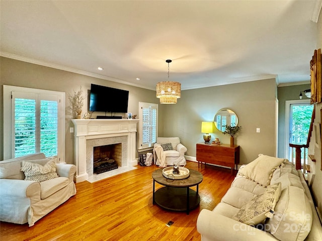 living room with a high end fireplace, plenty of natural light, crown molding, and hardwood / wood-style flooring