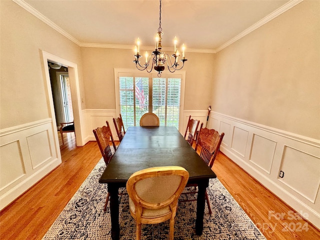 dining room featuring light hardwood / wood-style flooring, ornamental molding, and a chandelier