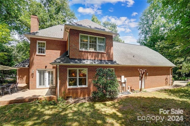 back of house with a lawn and a patio