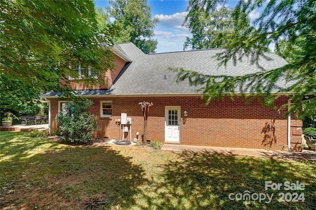 rear view of property featuring a lawn