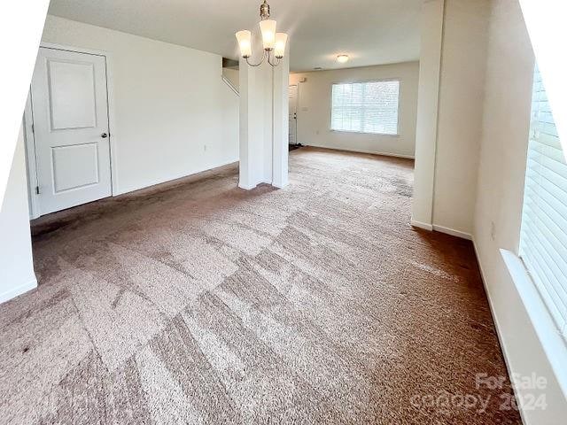 interior space featuring carpet flooring and an inviting chandelier