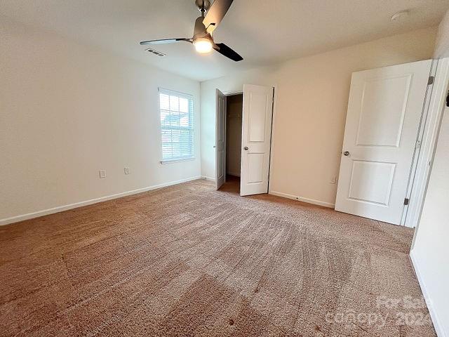 unfurnished bedroom featuring ceiling fan and carpet flooring