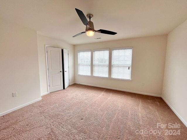 carpeted spare room featuring ceiling fan