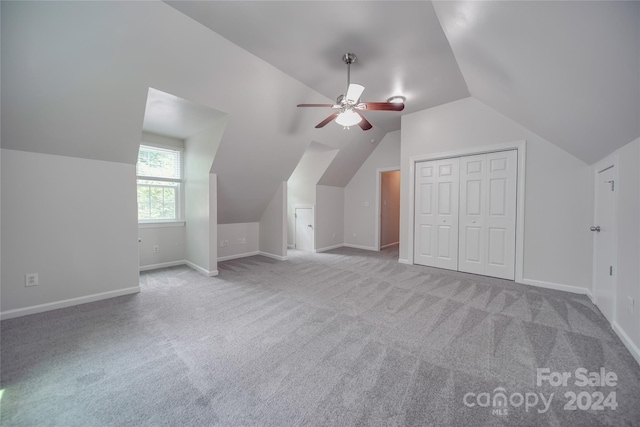 additional living space featuring ceiling fan, lofted ceiling, and light colored carpet